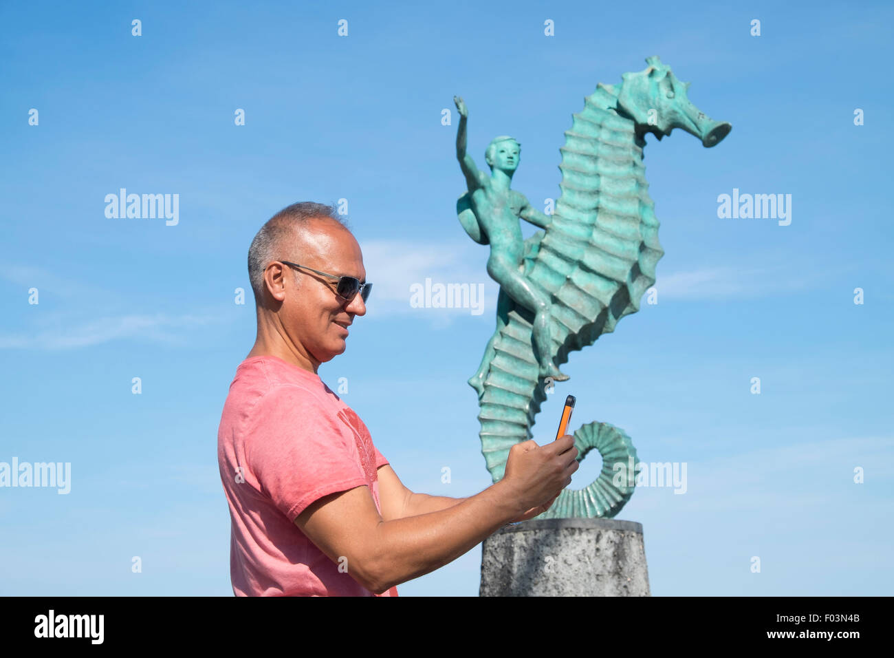 Tourist in Puerto Vallarta, Mexico. Man, 55 years old, hispanic ethnicity, taking selfie or checking hissmart phone. Stock Photo
