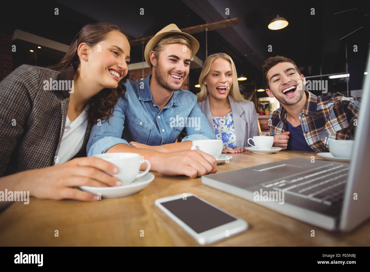 Laughing friends looking at laptop screen Stock Photo
