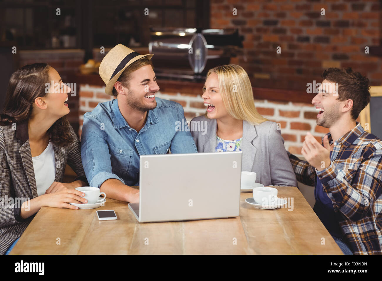 Smiling friends drinking coffee and laughing Stock Photo