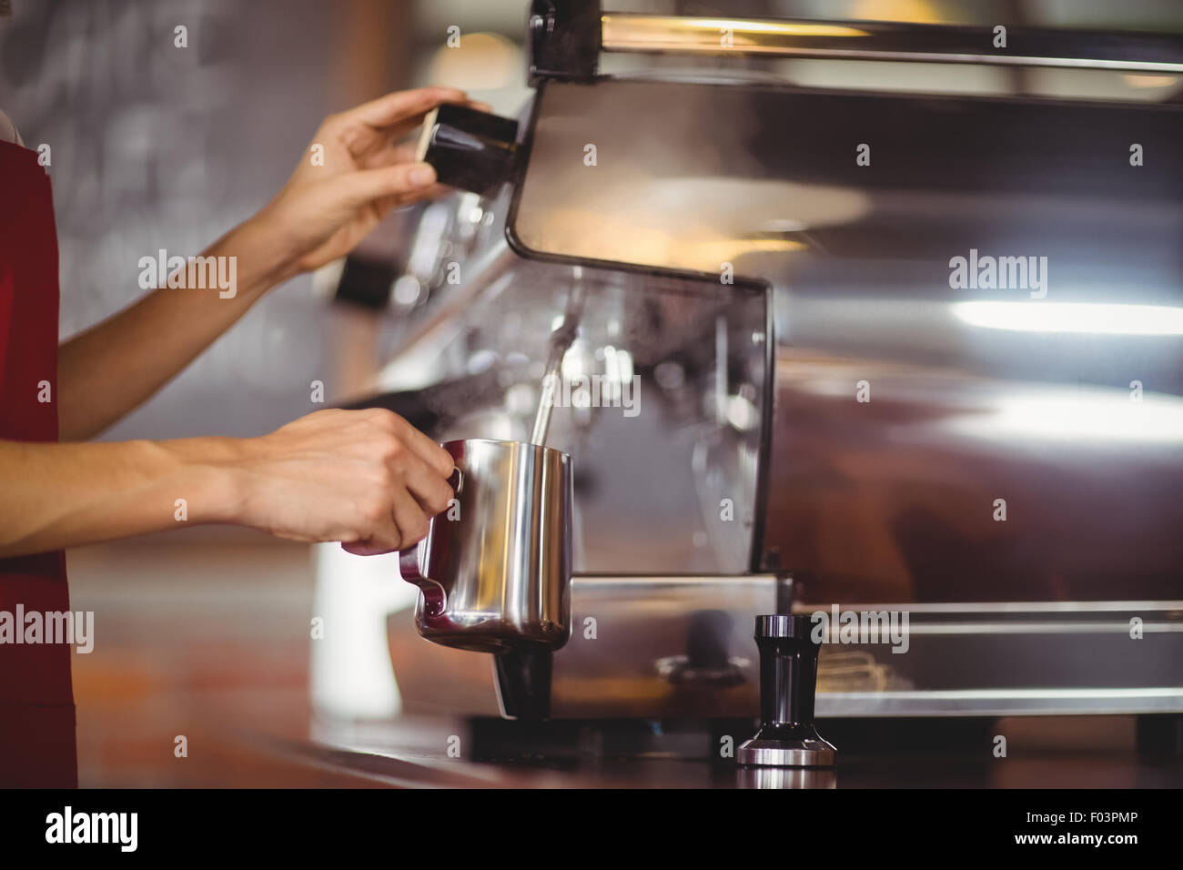 Barista steaming milk at the coffee machine Stock Photo Alamy