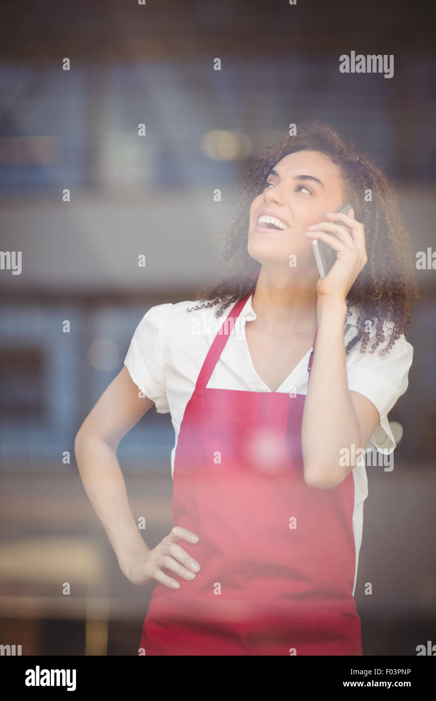 Smiling waitress talking on the phone Stock Photo