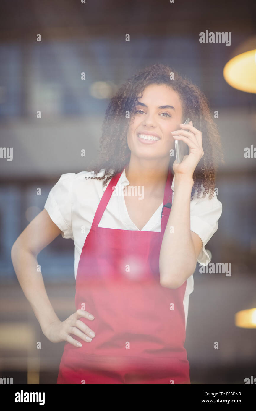 Smiling waitress talking on the phone Stock Photo