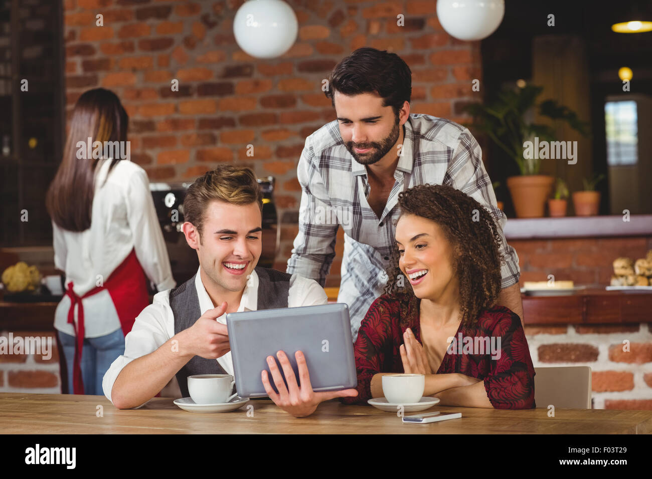 Smiling friends looking at digital tablet Stock Photo