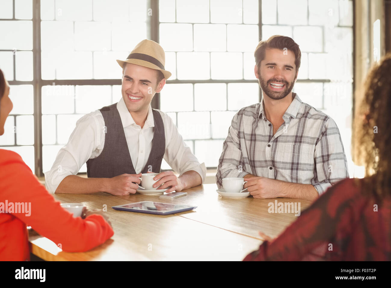 Laughing friends having coffee together Stock Photo