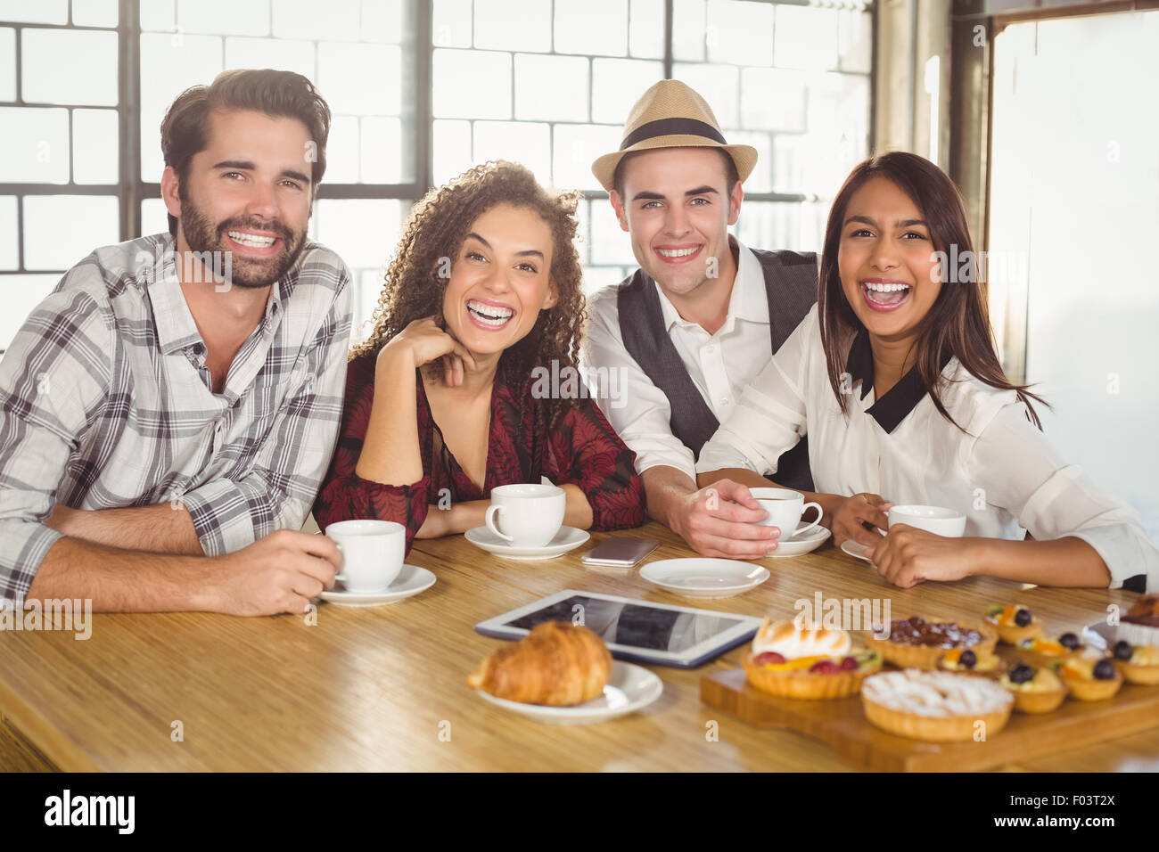 Laughing friends enjoying coffee and treats Stock Photo