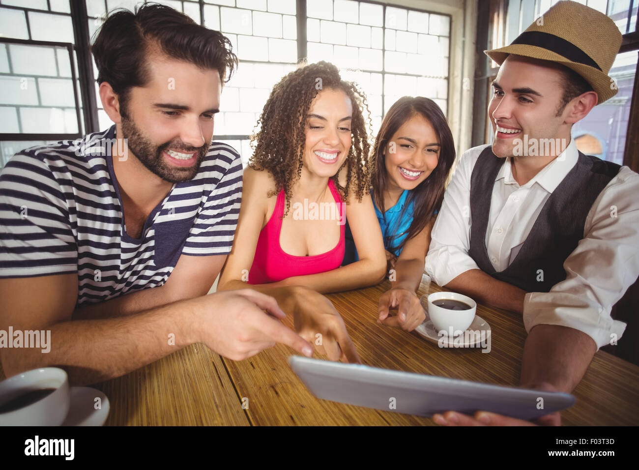 Laughing friends pointing and looking at tablet computer Stock Photo