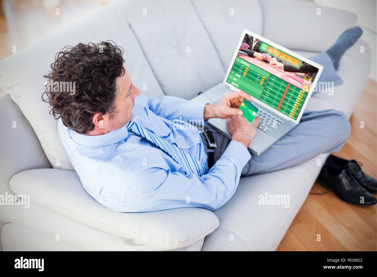Composite image of businessman doing online shopping on couch Stock Photo Alamy