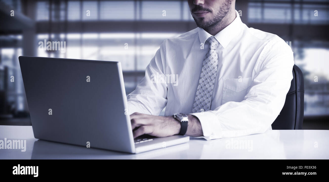 Cheerful businessman using laptop at desk Stock Photo