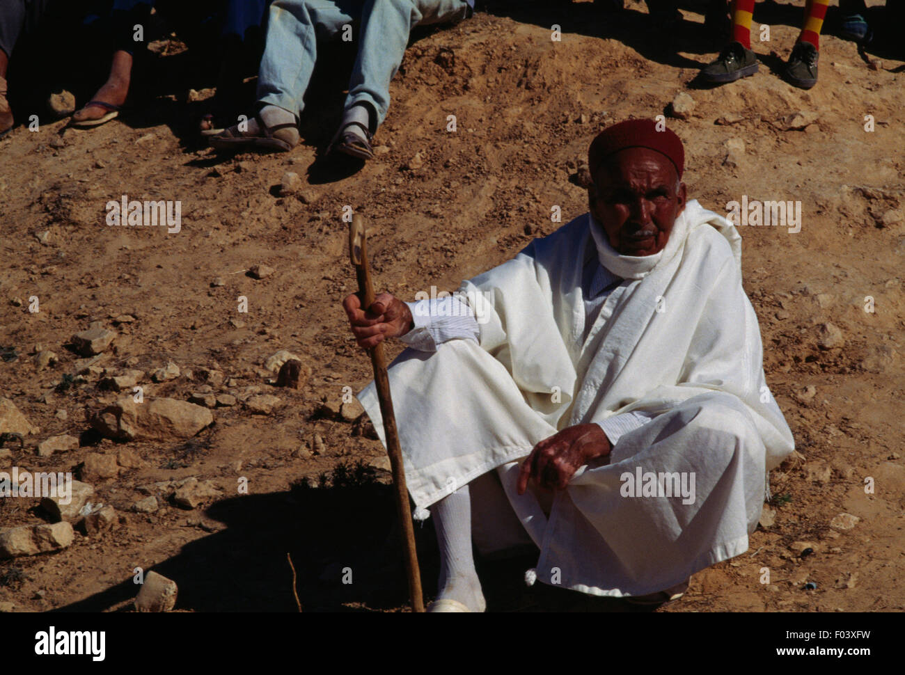 Man in traditional clothes sitting on the ground, Matmata Berber festival, Tunisia. Stock Photo