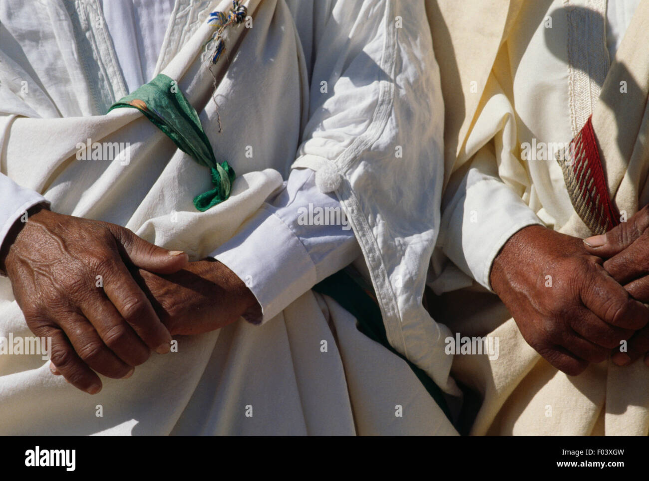 Men in traditional clothes, detail of the hands, Matmata Berber festival, Tunisia. Stock Photo