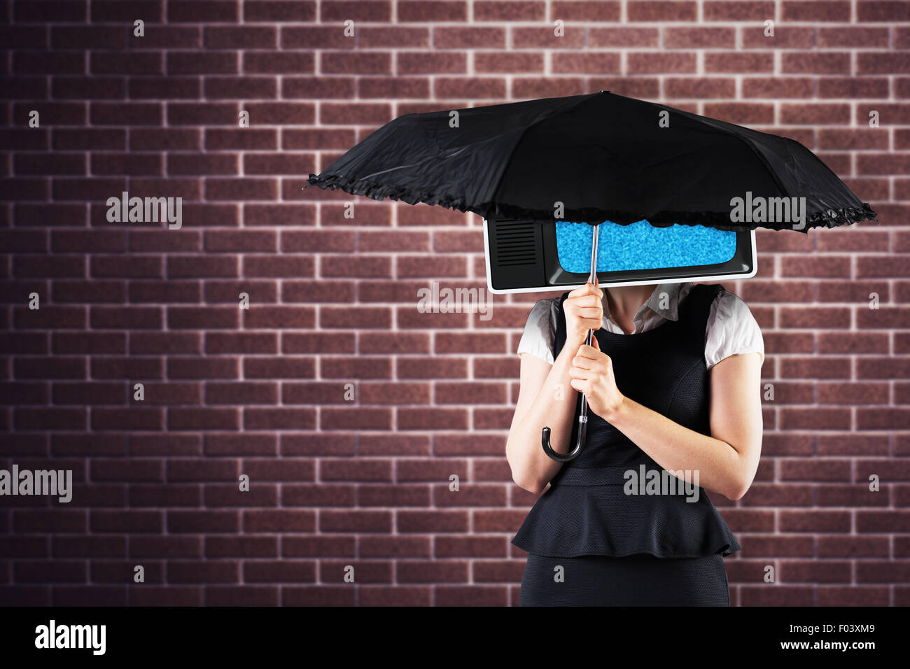 Composite image of pretty redhead businesswoman holding umbrella Stock Photo