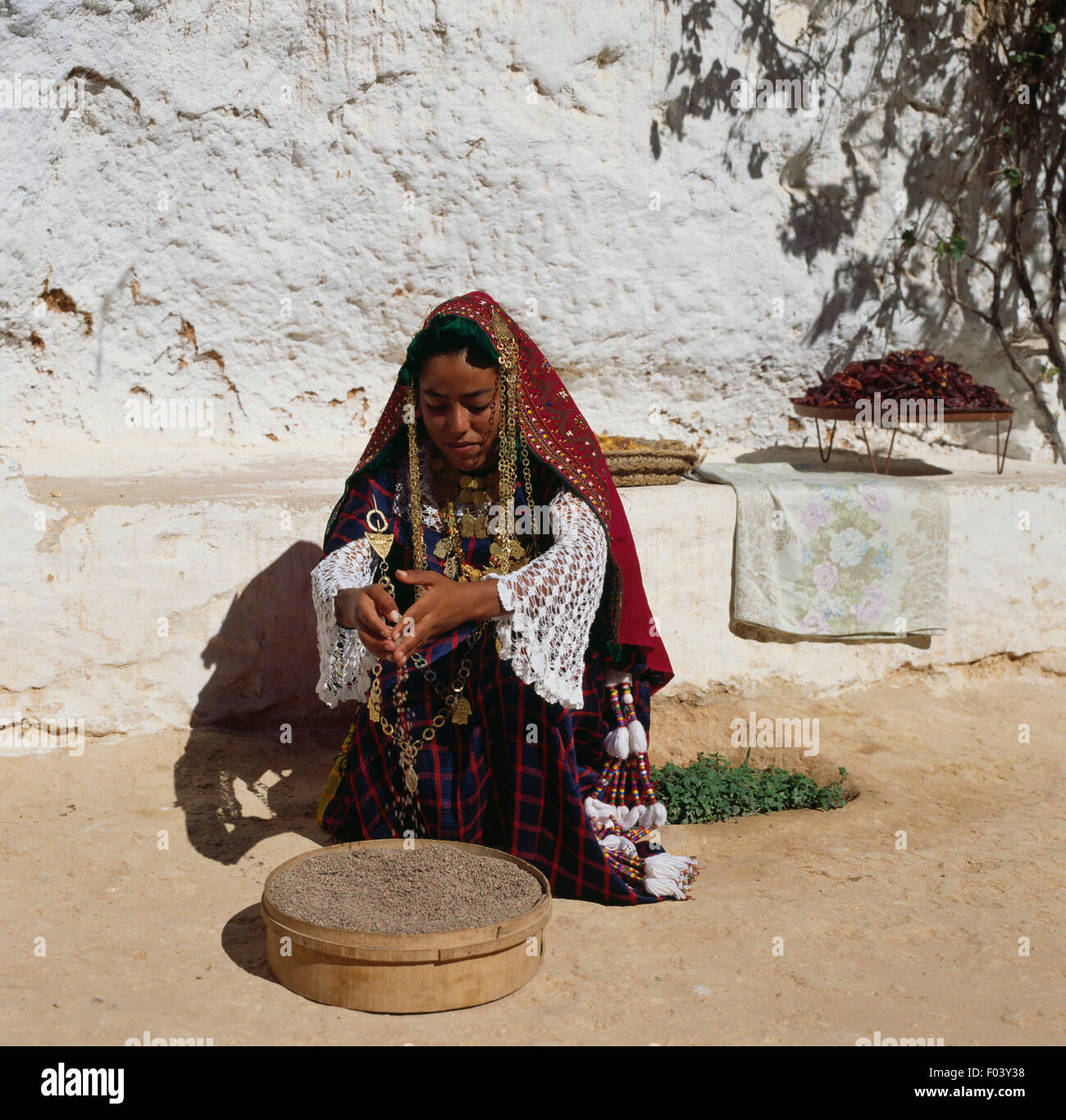 Berber girl in traditional clothes with a sieve, Matmata, Tunisia. Stock Photo