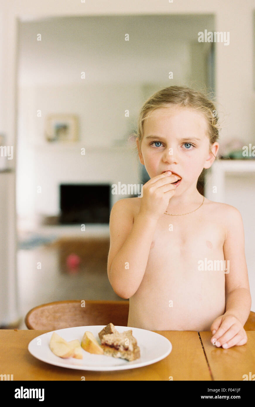 Preteen young kid girl nude model Nude young girl standing at a table, eating a sandwich and apple Stock  Photo - Alamy