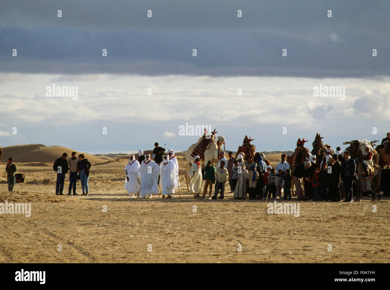 Men in traditional clothes with camels, Festival of the Sahara in Douz, Tunisia. Stock Photo