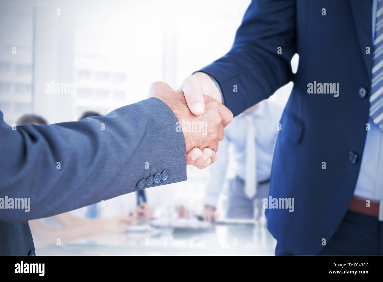 Composite image of businessmen shaking hands Stock Photo
