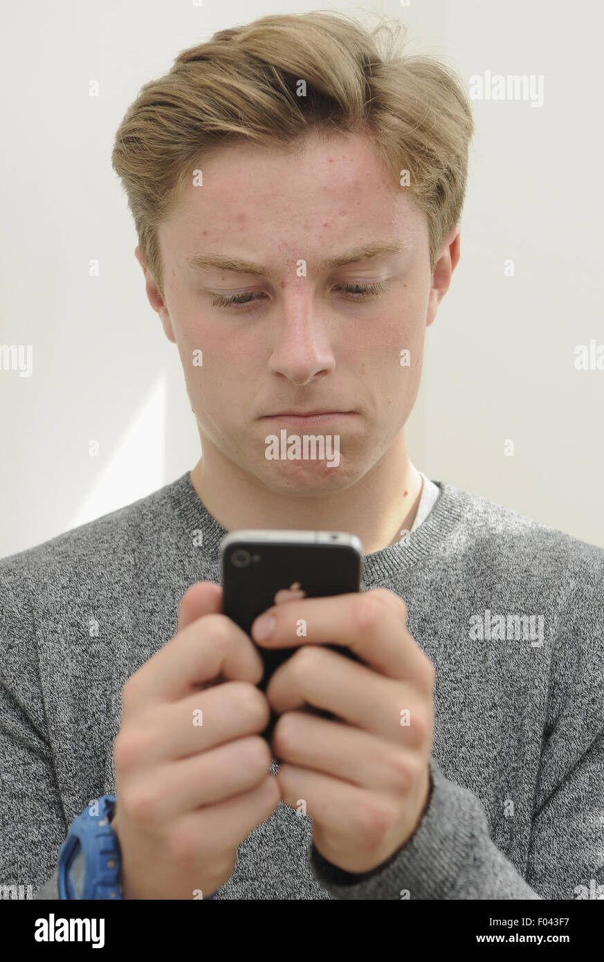 Teenage boy using an Apple iPhone4 mobile phone Stock Photo