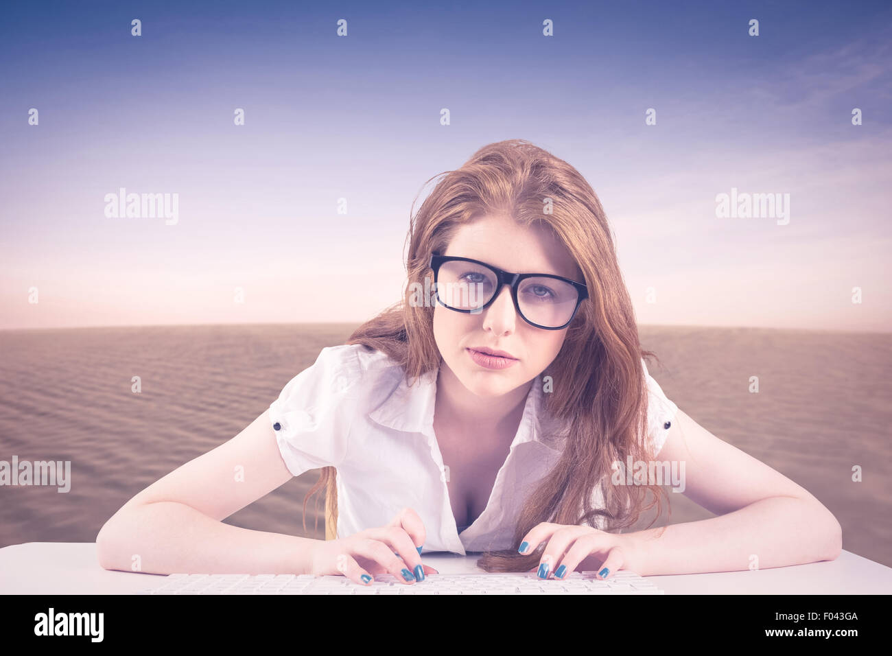 Composite image of pretty redhead typing on keyboard Stock Photo