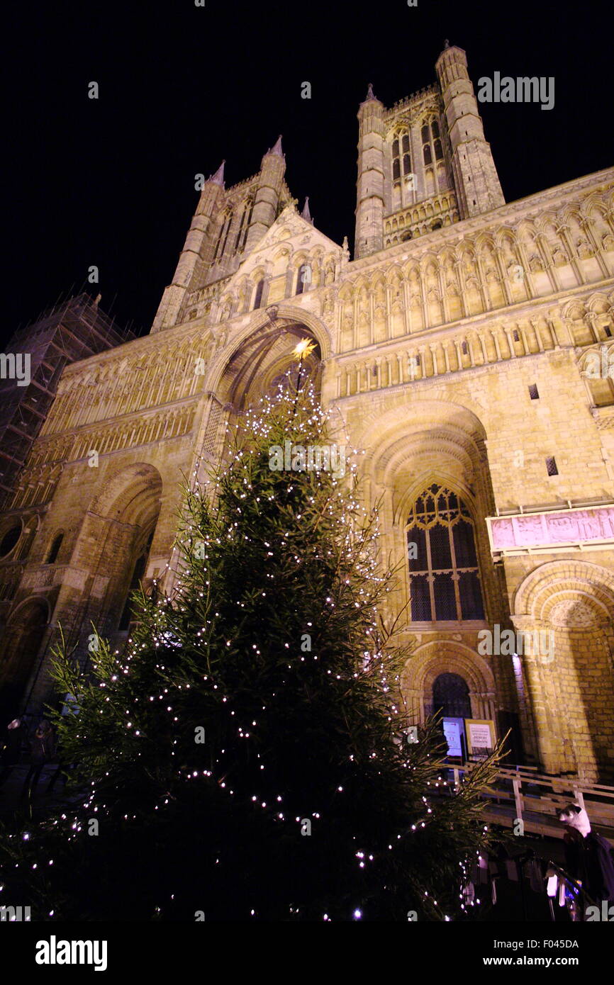 A Christmas tree outside the main entrance of an illuminated Lincoln Cathedral during the City's Christmas market, England UK Stock Photo