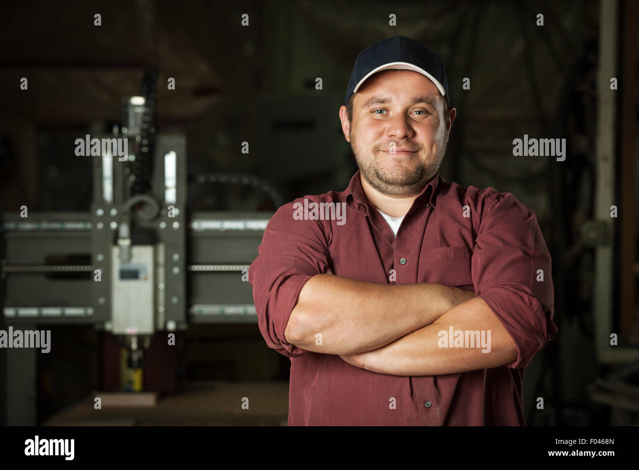 Portrait of happy professional carpenter at his work place. Stock Photo