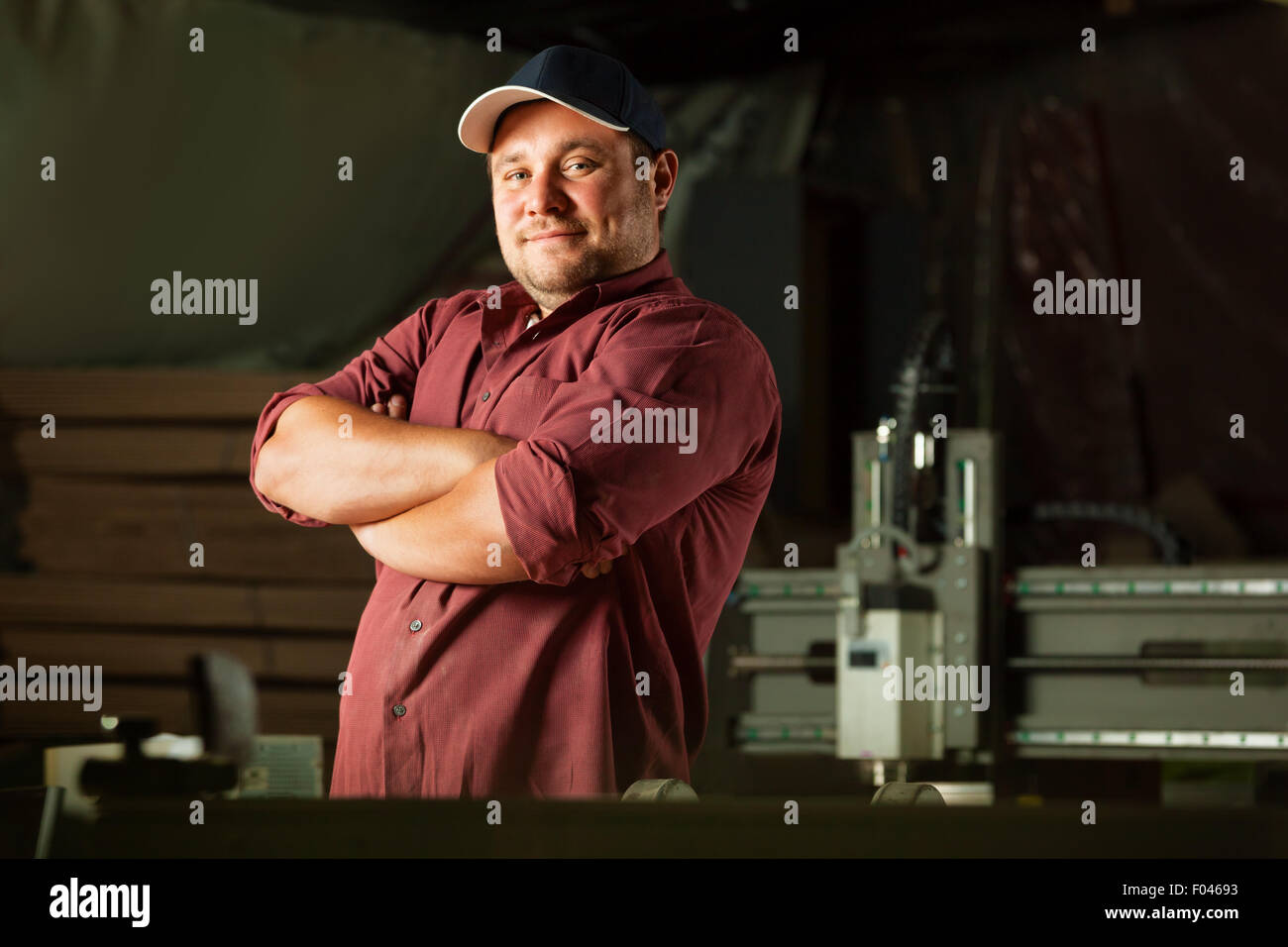 Portrait of happy professional carpenter at his work place. Stock Photo