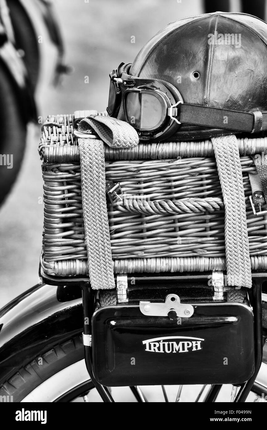 Old vintage leather helmet and goggles and wicker basket on a vintage Triumph motorcycle. Black and white Stock Photo