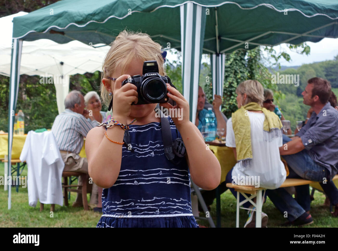 Child using DSLR camera at garden party in France Stock Photo