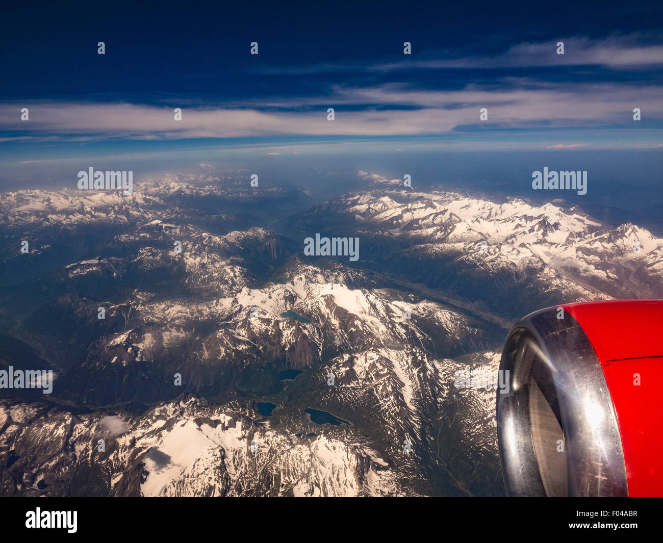The snow covered Alps mountain range shot from an aeroplane window. Stock Photo