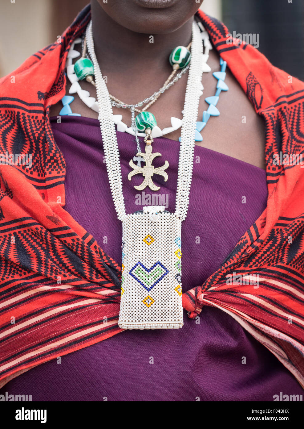 Beads phone case worn along with traditional necklaces by a Maasai woman in Tanzania, Africa. Stock Photo