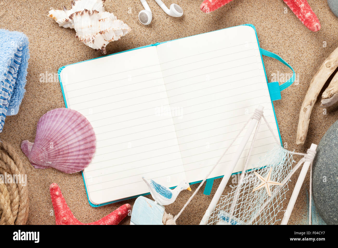 Notepad Sand Travel and vacation notepad with items over sea sand. Top view with ...