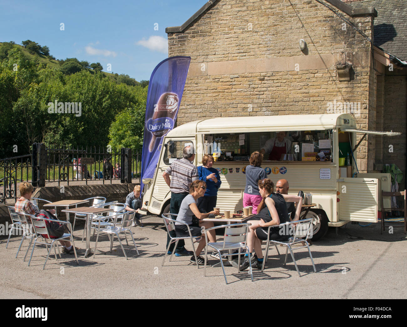 People sitting drinking coffee from vintage Citroen van on  Monsal Trail at Millers Dale station Derbyshire, England, UK Stock Photo
