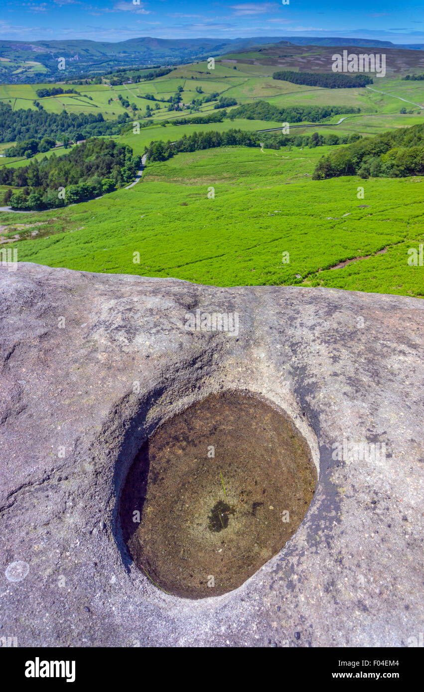 View west from gritstone cliff of Stanage Edge, Peak District, National Park, Derbyshire, with water filled pothole  foreground Stock Photo