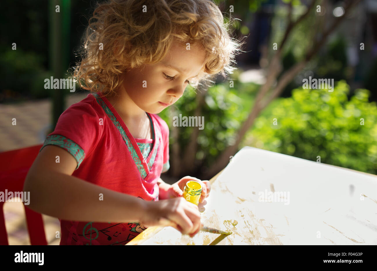 Portrait of little girl painting, summer outdoor Stock Photo