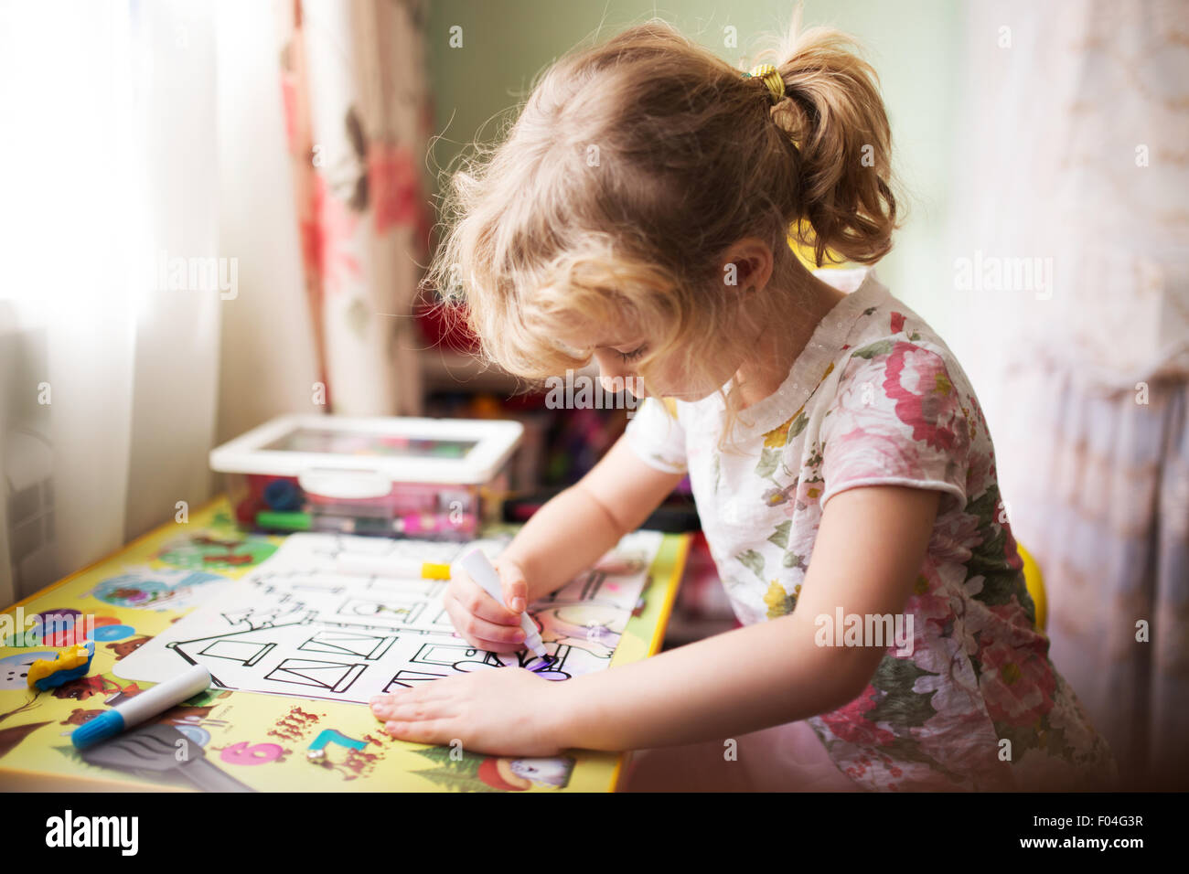 Little girl painting in her room at home, shallow dof Stock Photo