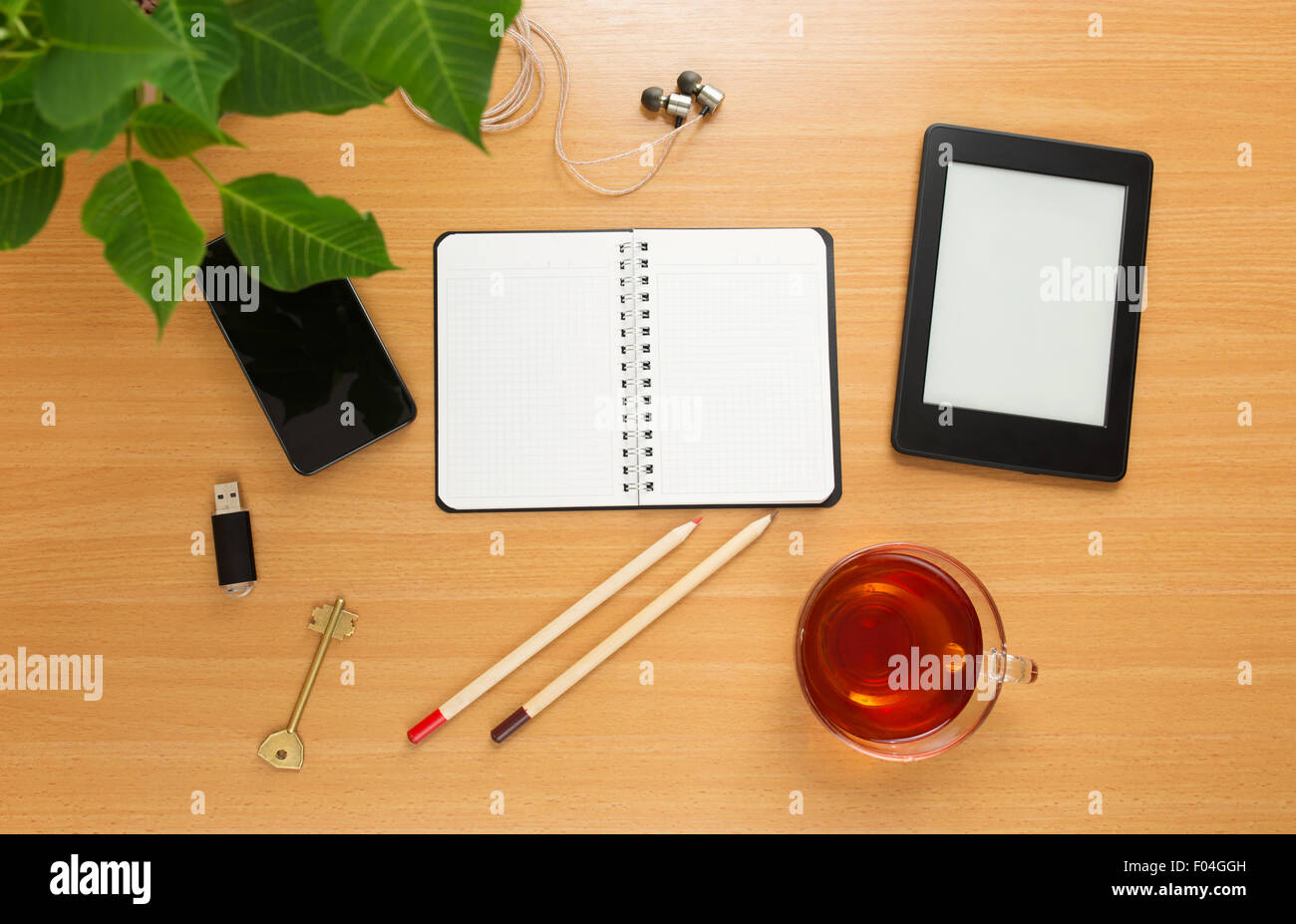 Office table with notepad, tea cup , pen , smartphone , headphone, tablet. View from above Stock Photo