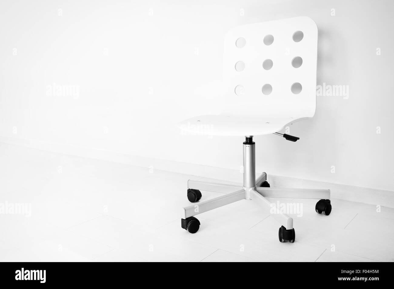 White chair against wall, black and white photo Stock Photo