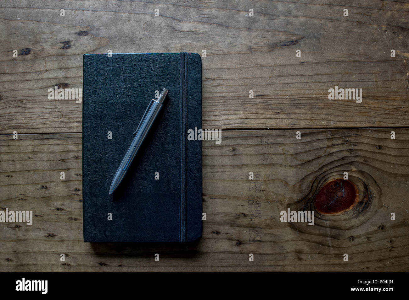 Leather Notebook with Silver Pen on a Wooden Table Stock Photo
