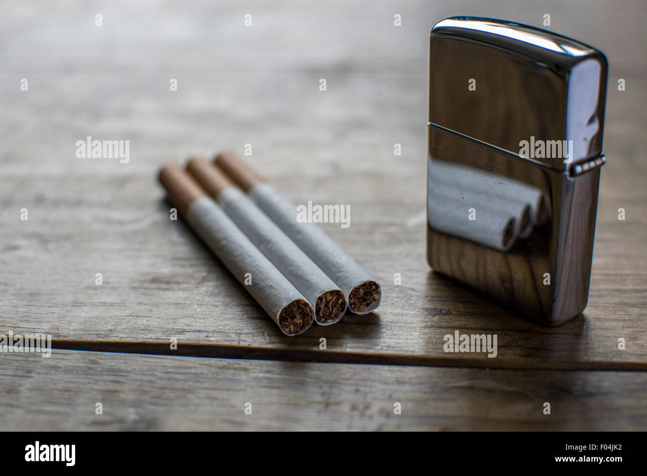 Cigarettes with Reflective Silver Zippo Stock Photo - Alamy