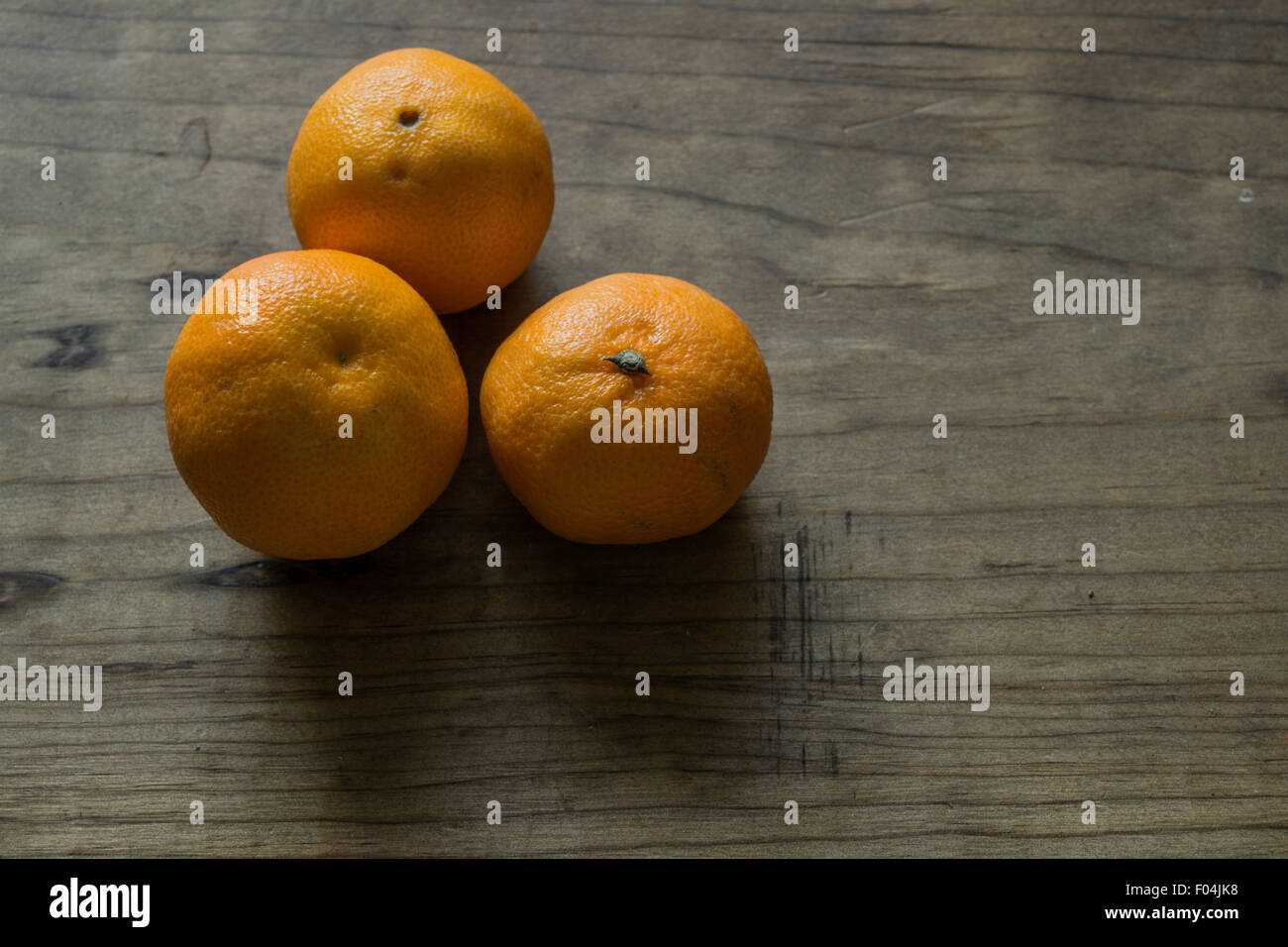 Three Clementines on a Wooden Table Stock Photo Alamy