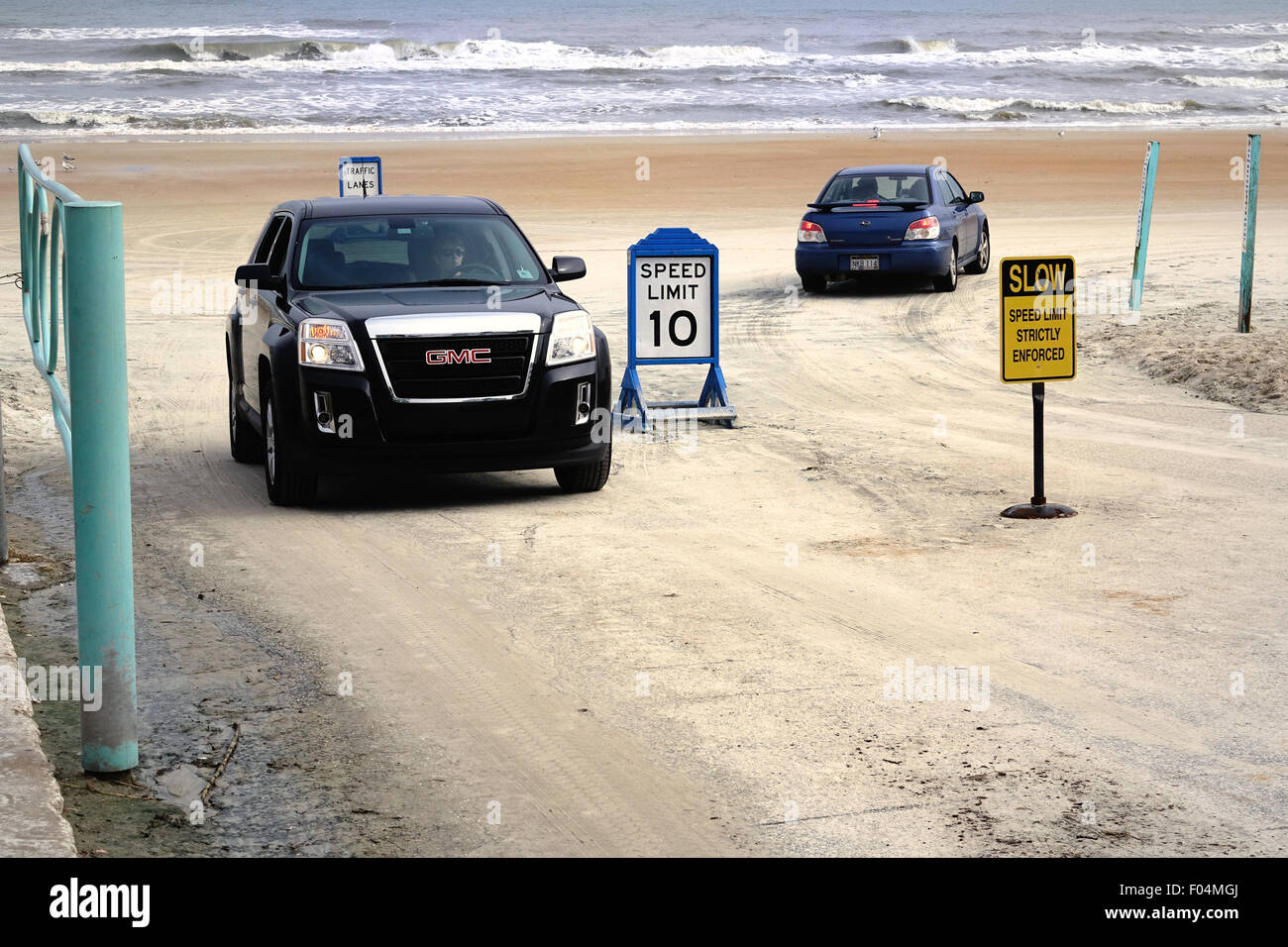 One car leaves the traffic lanes on Daytona Beach while another car