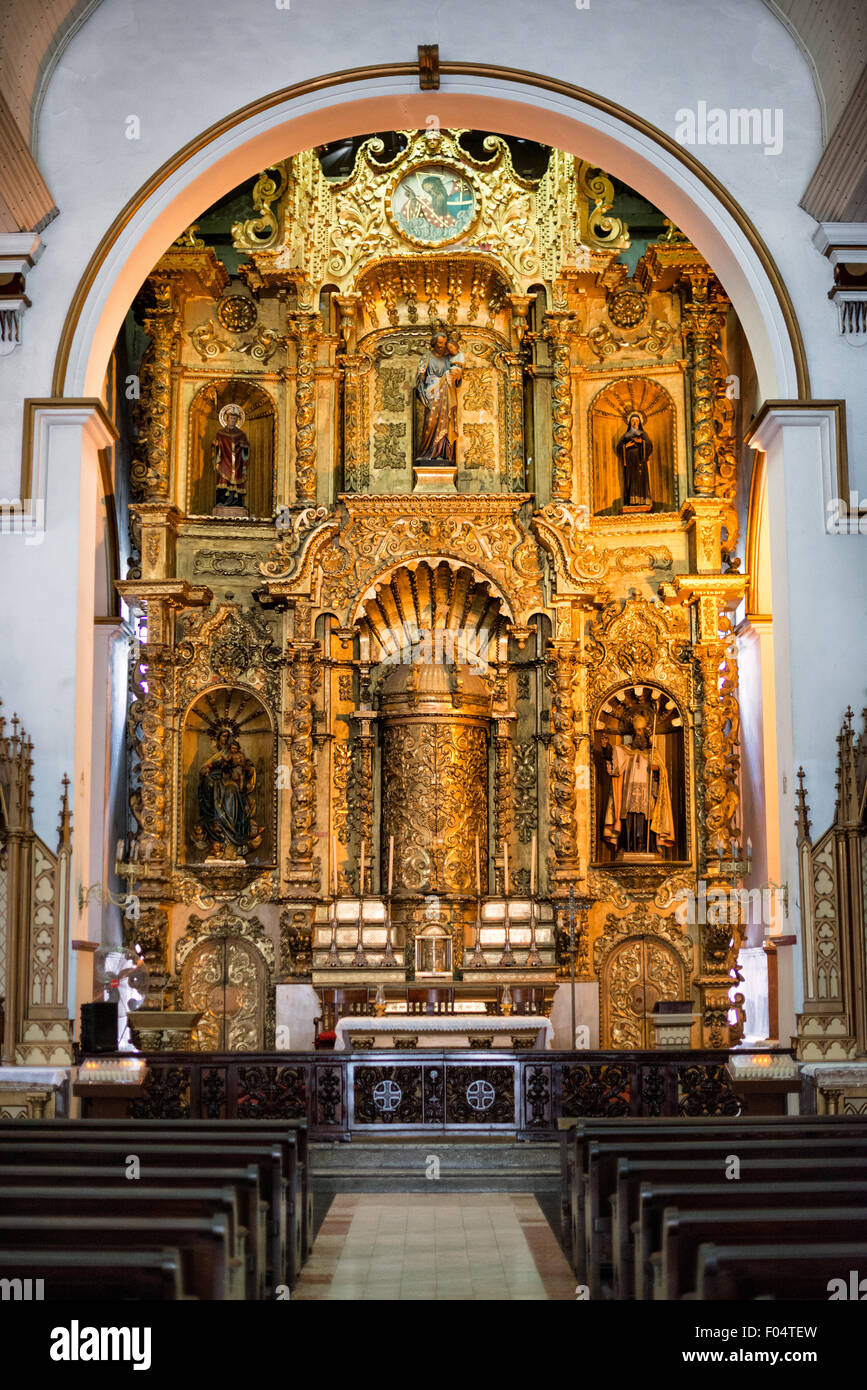 Altar de Oro Iglesia San José Panama City Panama // PANAMA CITY, Panama — The golden altar (Altar de Oro) at Iglesia San José stands as one of Panama's most significant colonial religious artifacts. According to historical accounts, this carved mahogany altar, covered in gold paint, survived pirate Henry Morgan's 1671 raid on Panama Viejo when quick-thinking priests concealed it under black paint. The altar was later relocated to its present site in Iglesia San José, constructed in 1673 in what is now the Casco Viejo historic district. Stock Photo