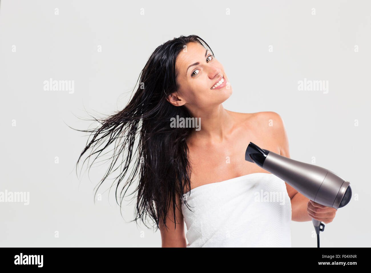 Pretty young woman in towel drying her hair isolated on a white ...
