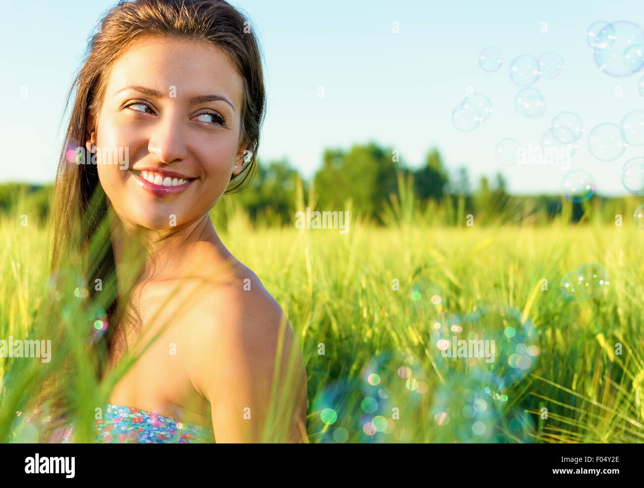 Portrait of a beautiful young happy woman in the summer on the nature. Stock Photo