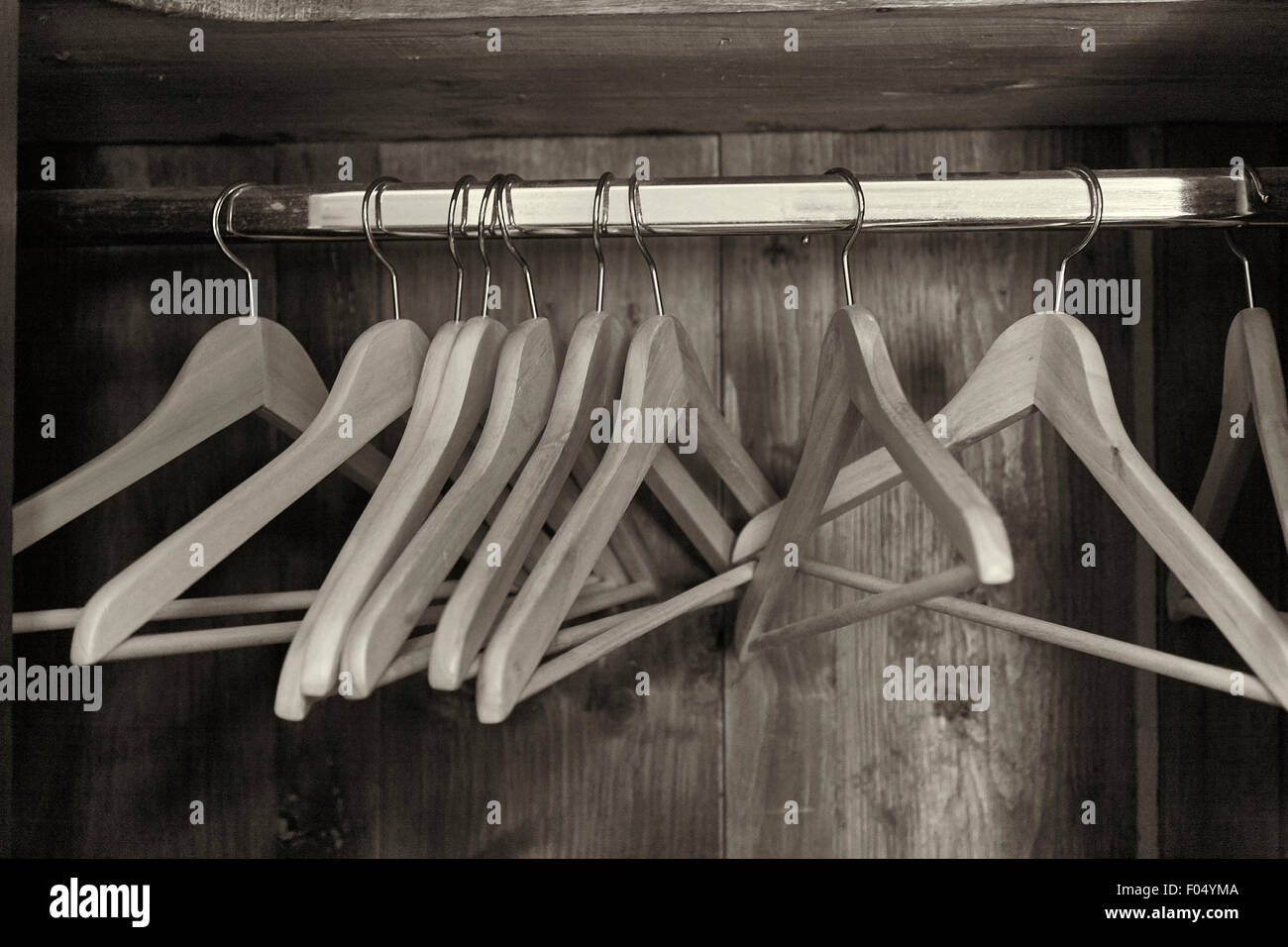An open wardrobe rail with wooden coat hangers Stock Photo