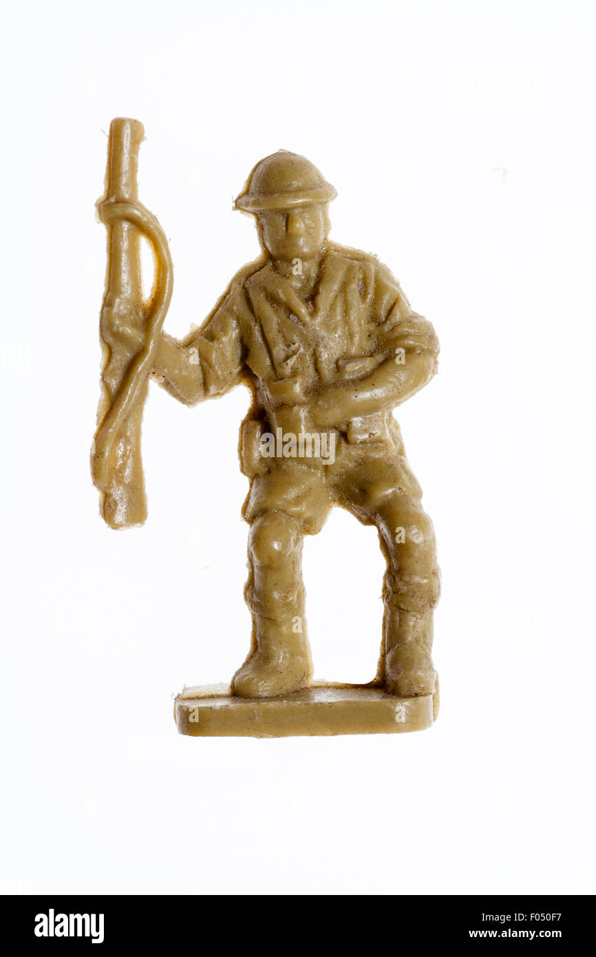 Airfix HO/00 scale model toy figure. First series 8th Army world war two soldier, carrying rifle, clutching chest after being shot. Plain background. Stock Photo