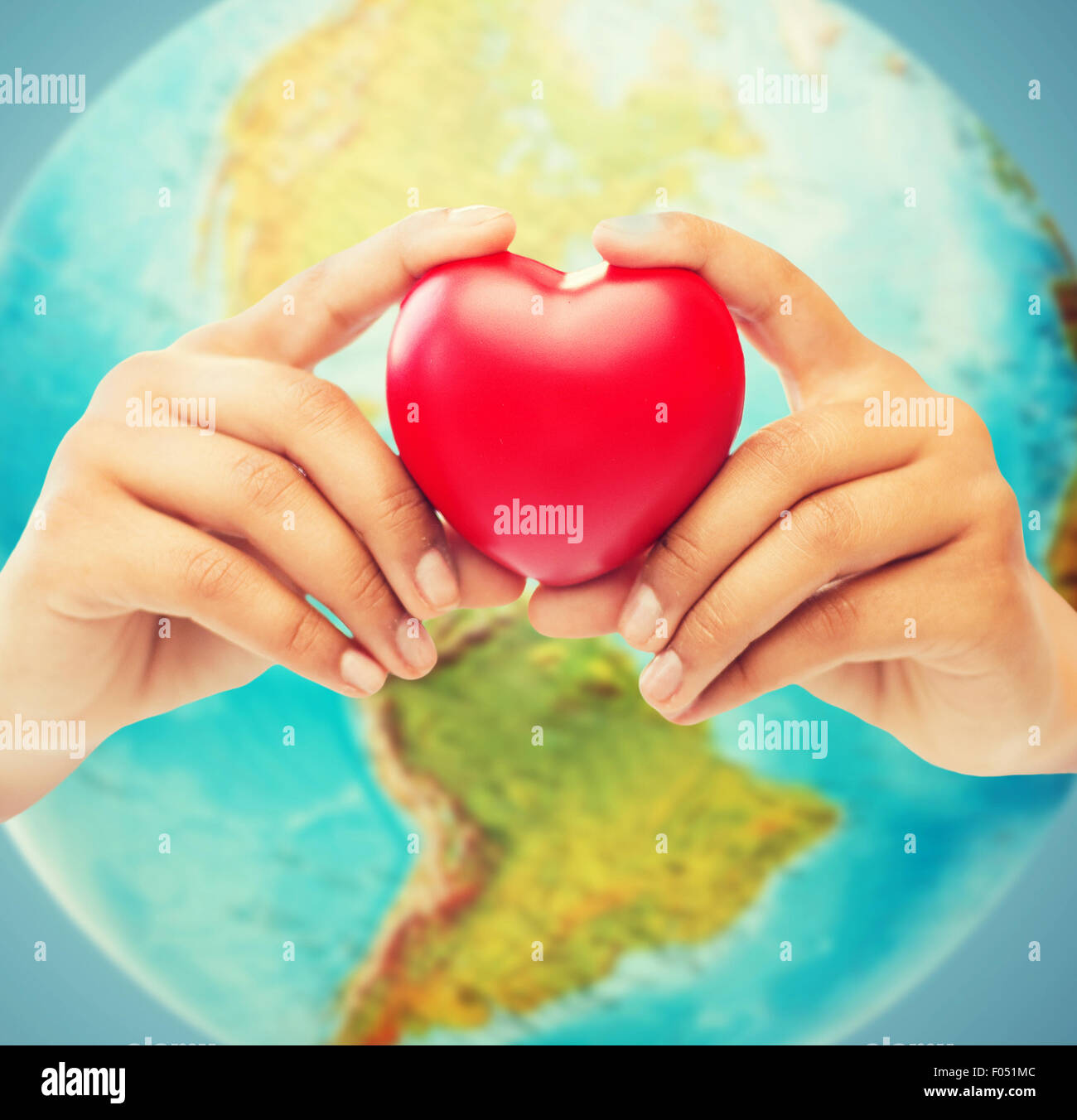 woman hands holding red heart over earth globe Stock Photo - Alamy