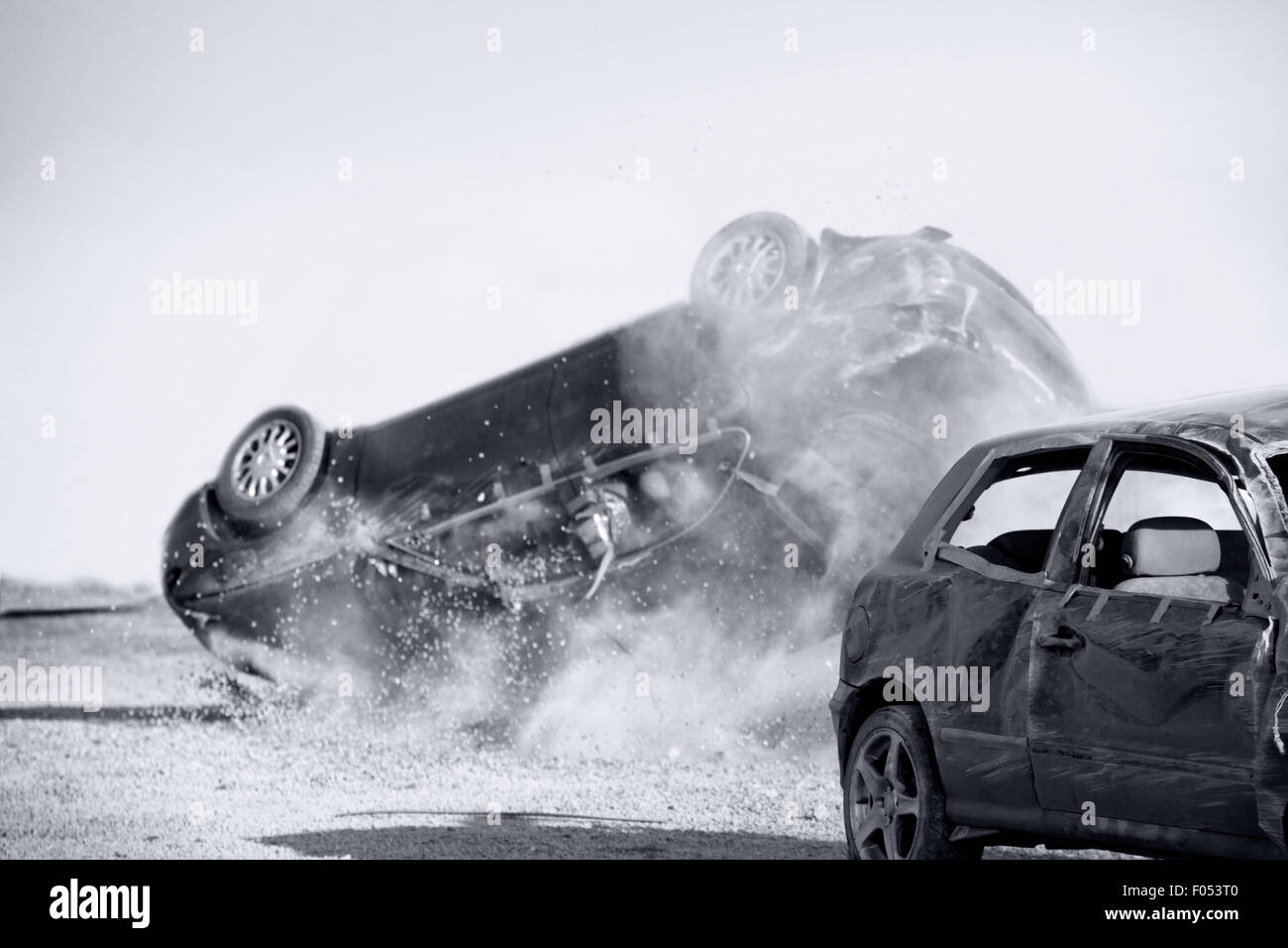 two cars turned upside-down after road collision, monochromatic Stock Photo