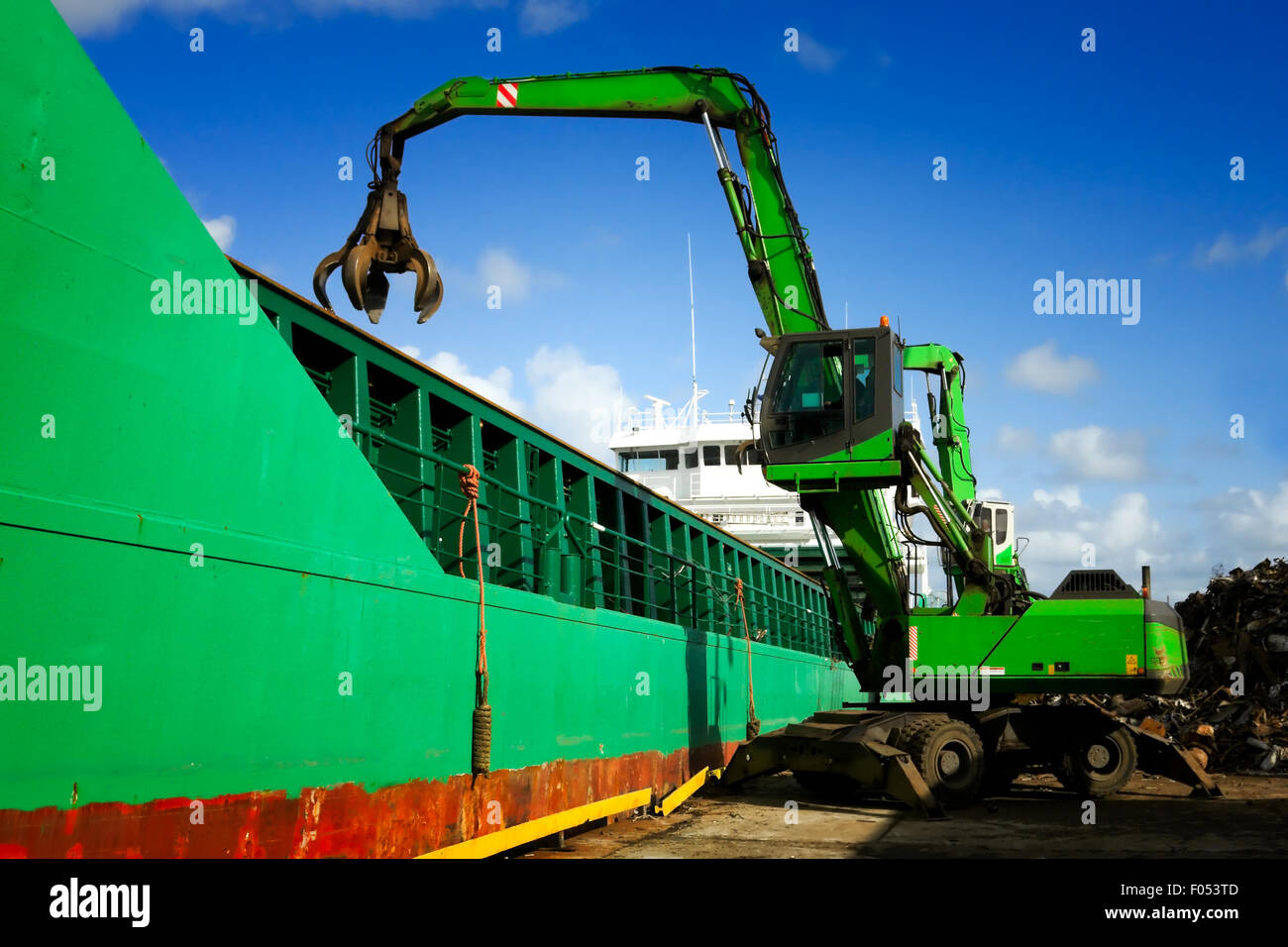 Crane loading a ship with metal scrap Stock Photo
