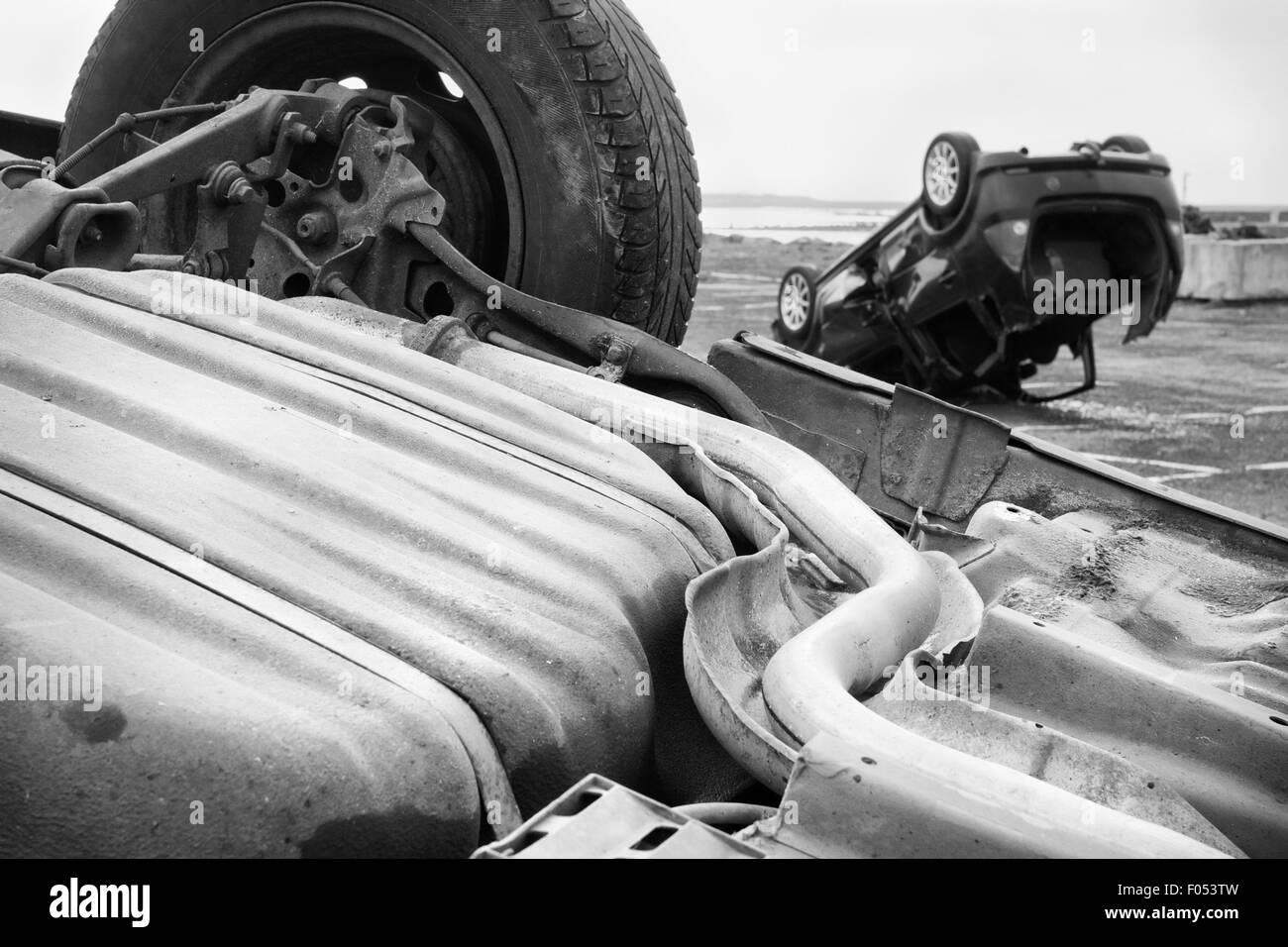 two cars turned upside-down after road collision. Monochromatic Stock Photo