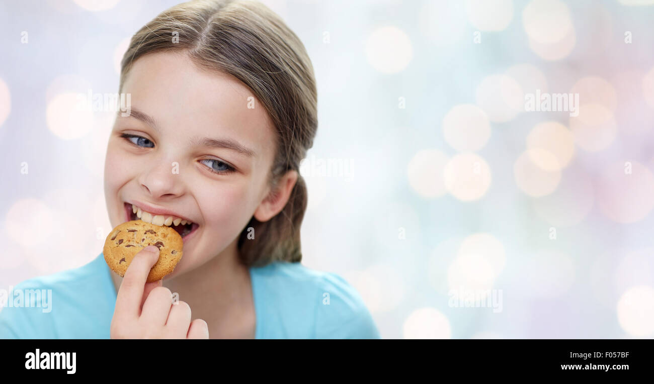 smiling little girl eating cookie or biscuit Stock Photo Alamy