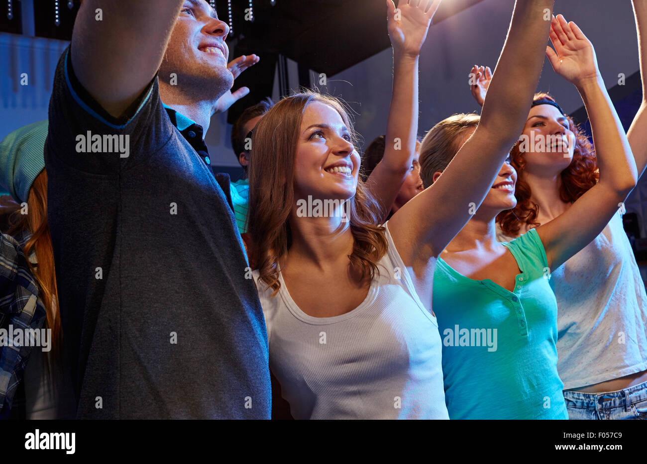 smiling friends at concert in club Stock Photo